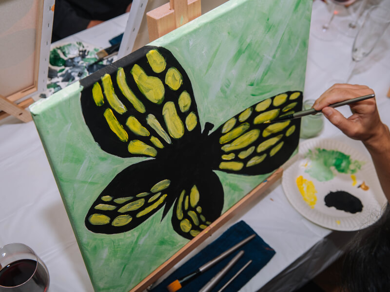 A person learns to paint a butterfly.